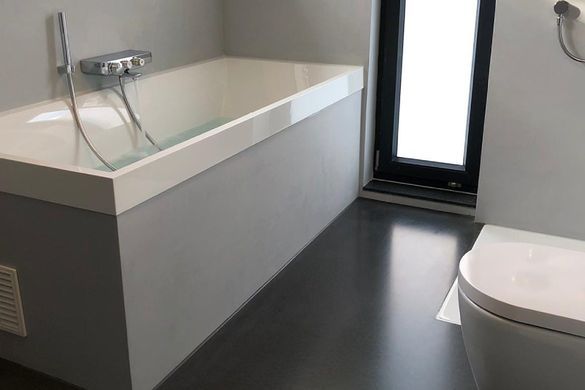 Badewanne und Toilette auf glänzend schwarzem Epoxitboden