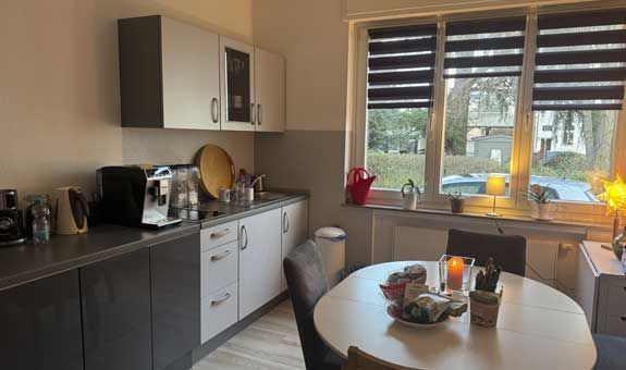 Eine Küche mit Tisch und Stühlen und einem Fenster.