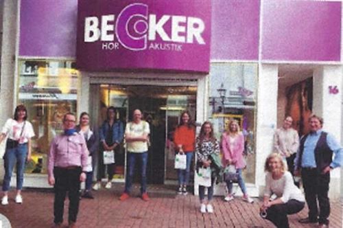 Eine Gruppe von Menschen steht vor einem Geschäft namens Becker