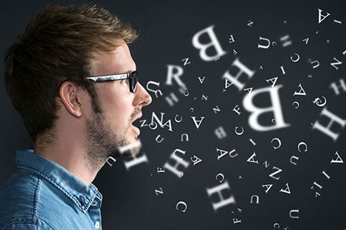 Ein Mann mit Brille spricht, und aus seinem Mund kommen Buchstaben.