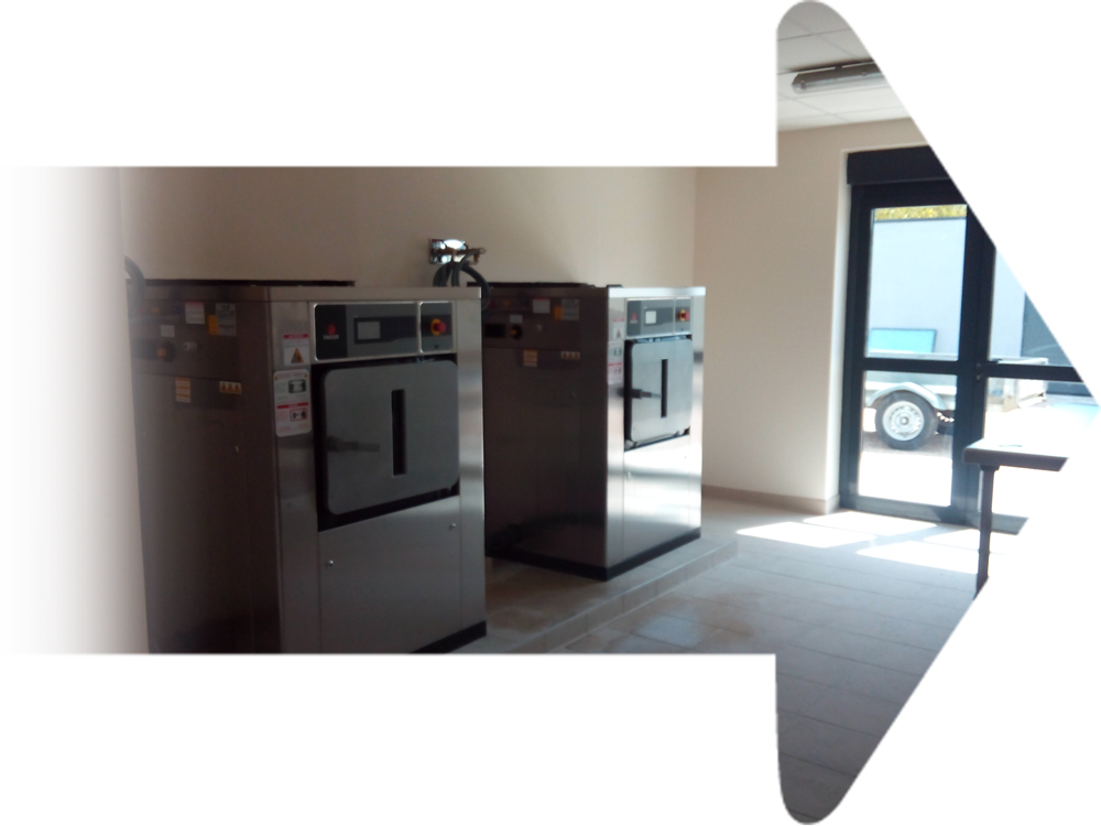 Deux grands fours industriels en métal dans une pièce avec une porte donnant sur l'extérieur.