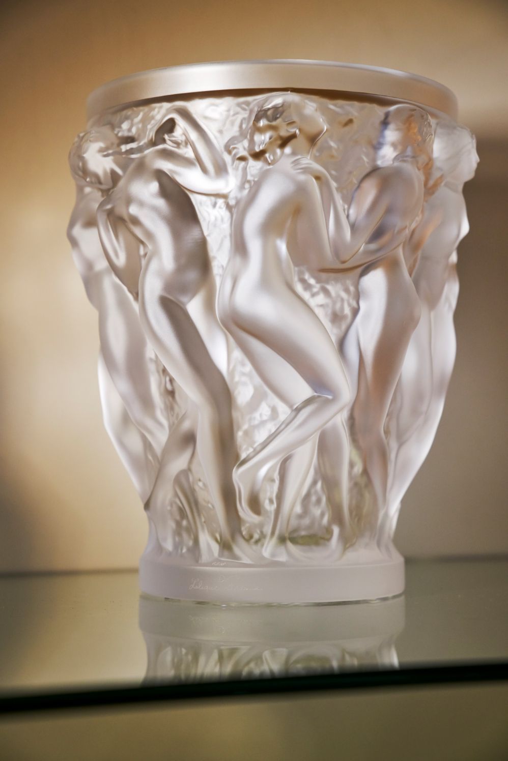 Sehr filigranes Glas mit aufwendig gestalteter Struktur auf gläsernem Tisch.