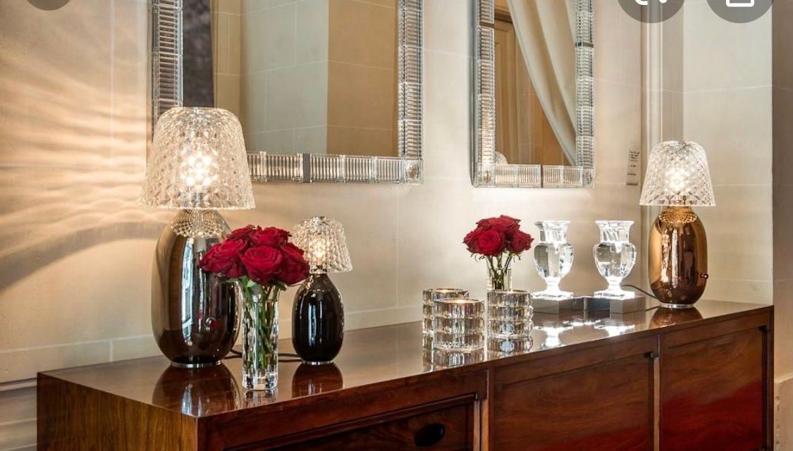 Zierliches Arrangement aus Tischlampe und frischen Blumen auf einem modernen Sideboard.