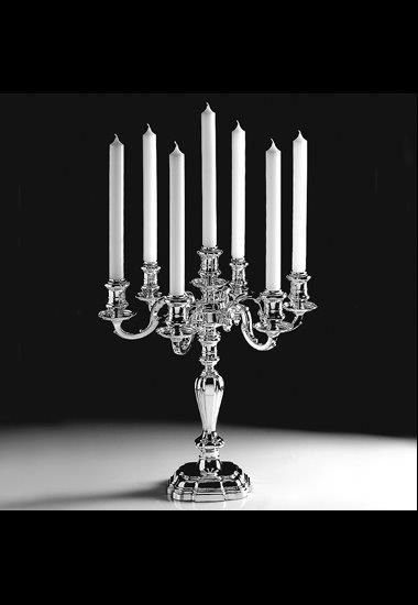 Eleganter Kerzenständer vor dunklem Hintergrund, puristisch arangiert.