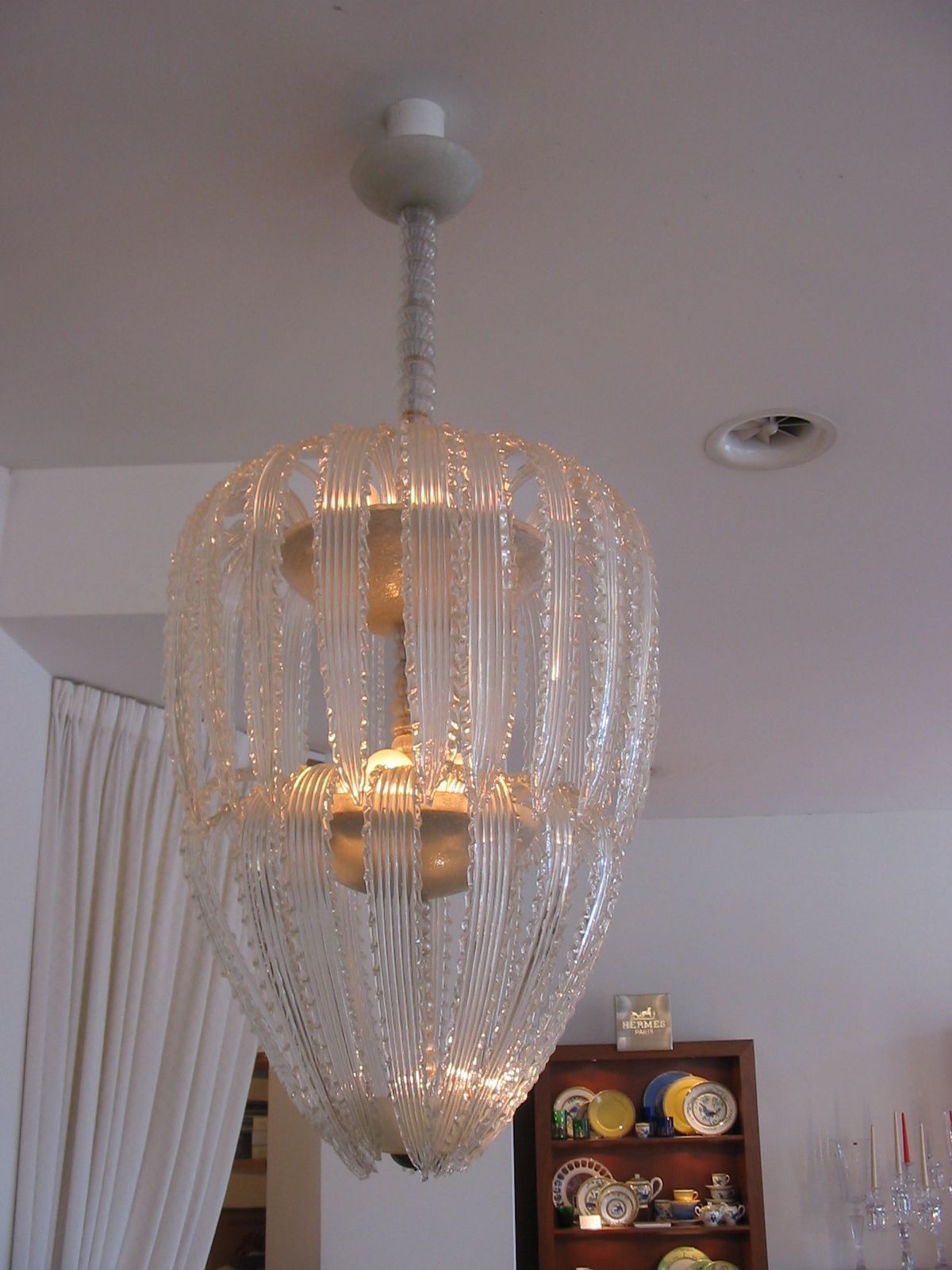 Opulenter Kronleuchter mit funkelnden Kristallanhängern, elegant herabhängend von einer prächtig verzierten Decke.