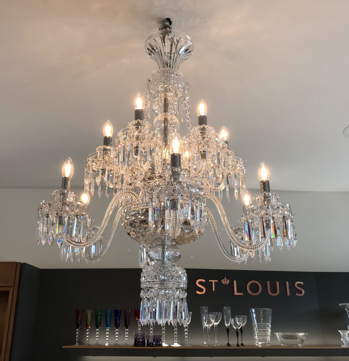 Vintage-Kronleuchter mit geschwungenen Armen und zarten Glühlampen, die ein warmes, einladendes Licht erzeugen.