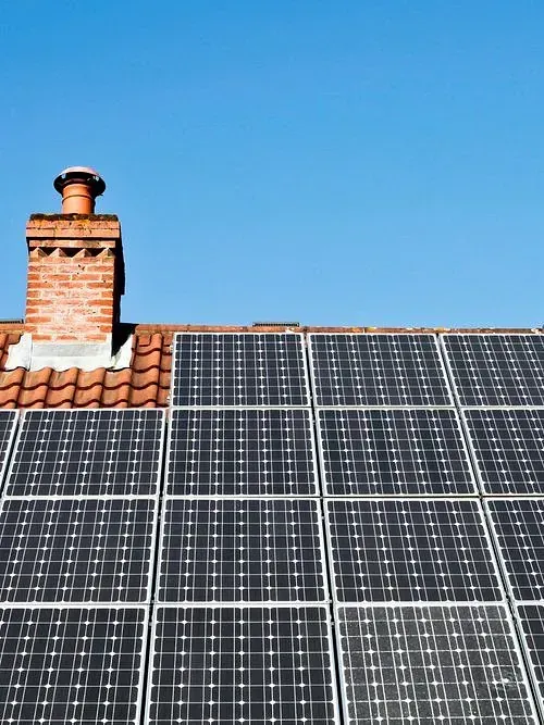 Hay muchos paneles solares en el tejado de una casa.