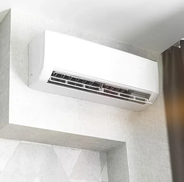 Un acondicionador de aire blanco cuelga del techo de una habitación.