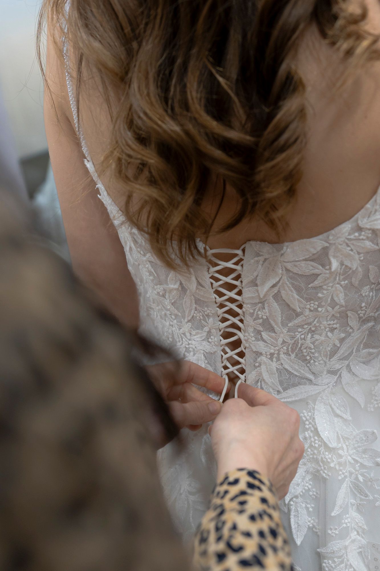 Une personne noue le corset d'une robe