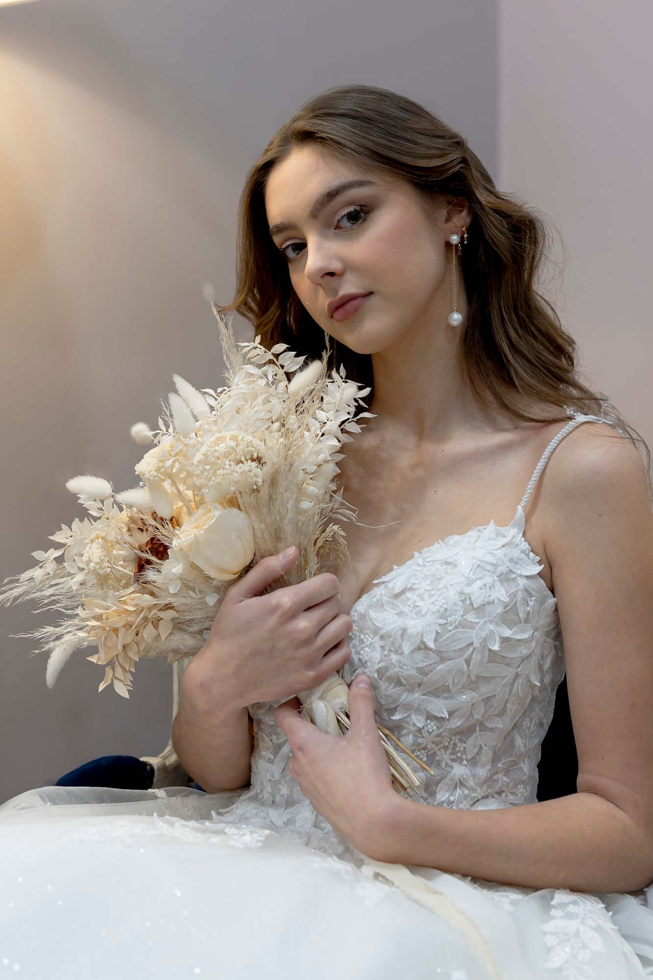 Une femme tient un bouquet de fleurs séchées