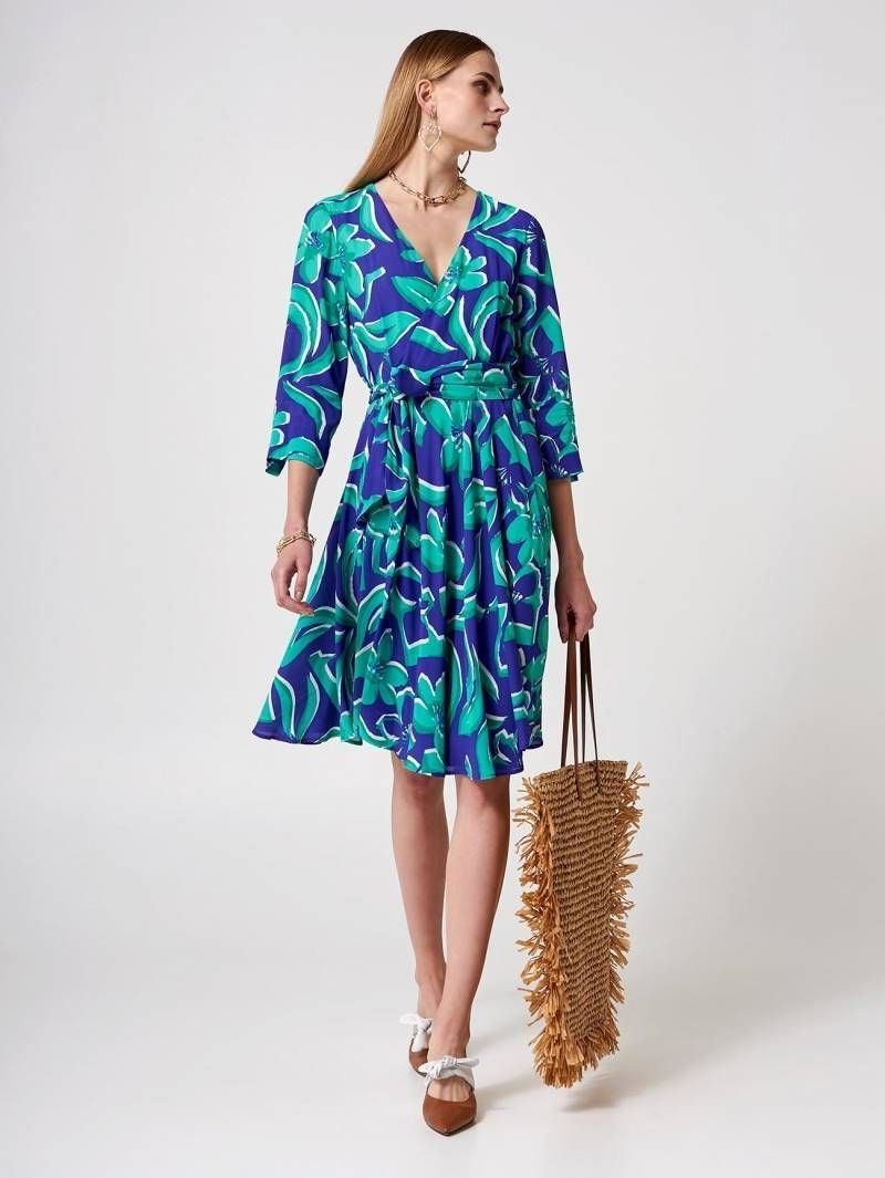 Une femme portant une robe de cocktail bleue et verte