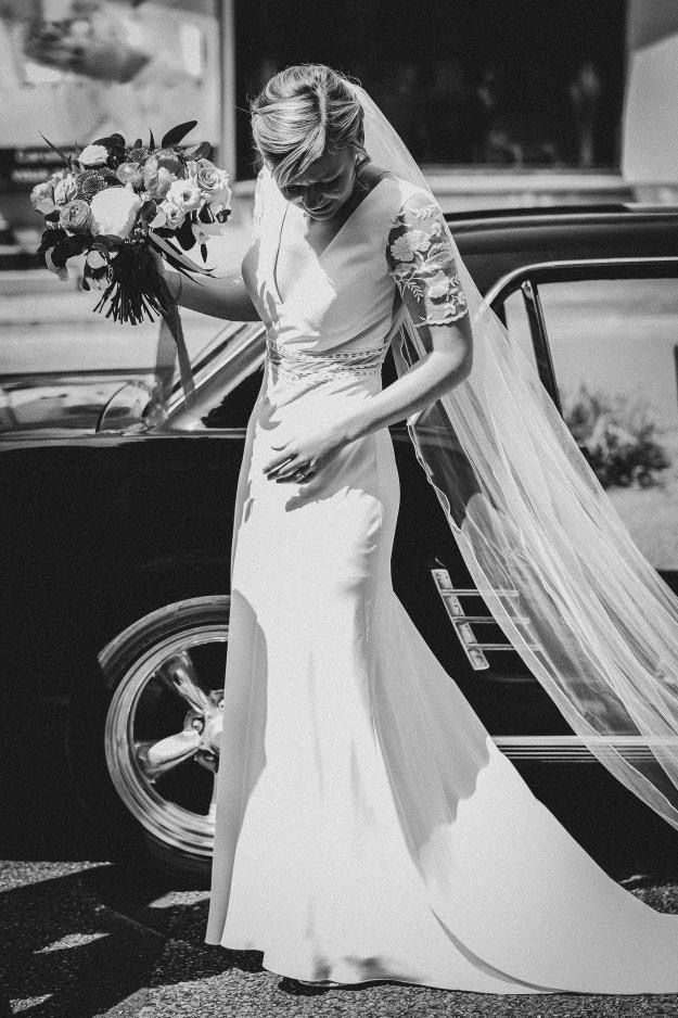 Une femme en robe de mariée tenant un bouquet de fleurs