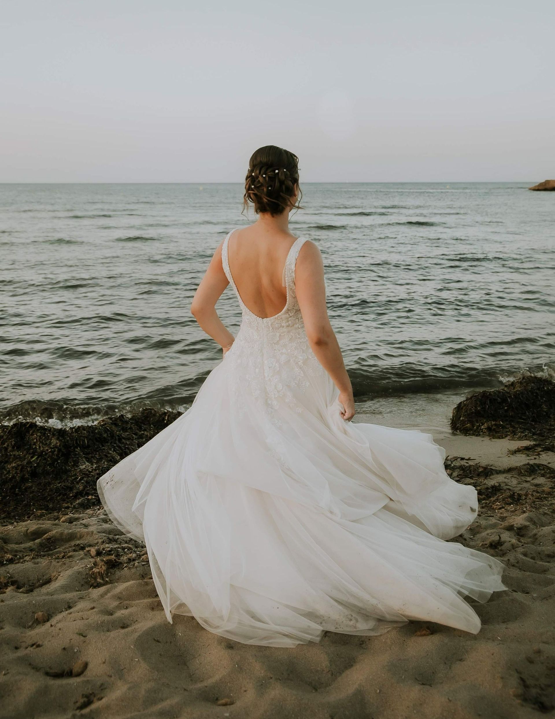 Une femme en robe de mariée sur la plage