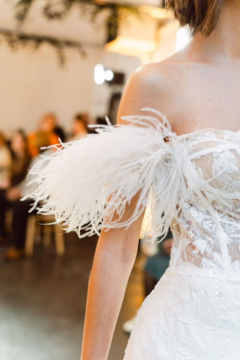 Vue de près d'une manche en plumes d'une robe de mariée