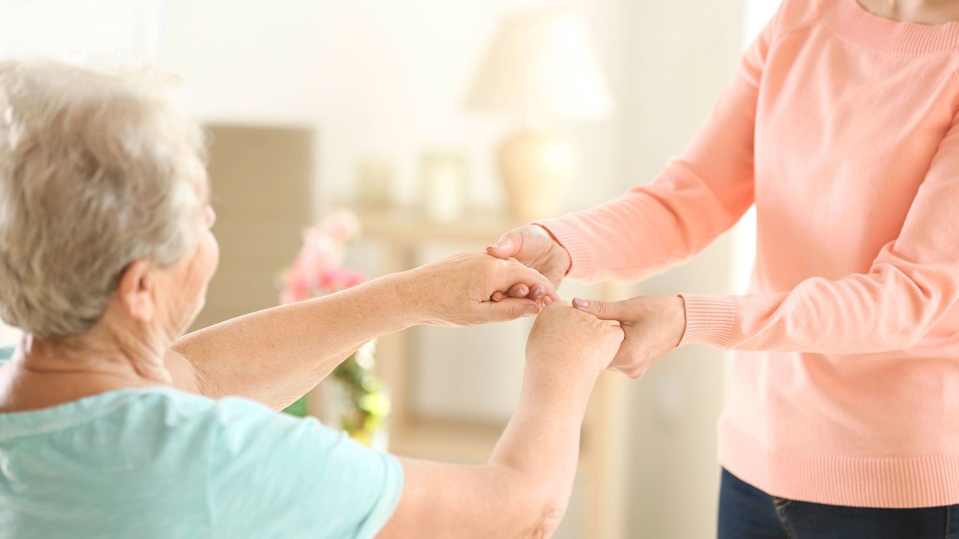 Eine ältere Frau schüttelt einer jüngeren Frau die Hand.