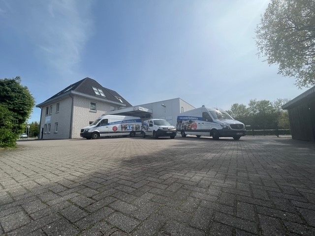 Drei weiße Lieferwagen stehen vor einem Gebäude