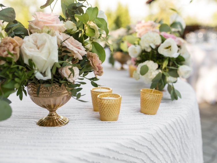 Una mesa con un jarrón de flores y velas encima.