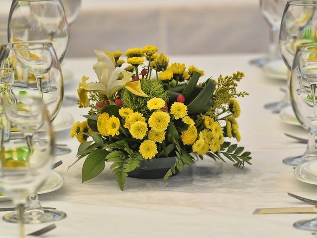 Un ramo de flores amarillas en un jarrón sobre una mesa.