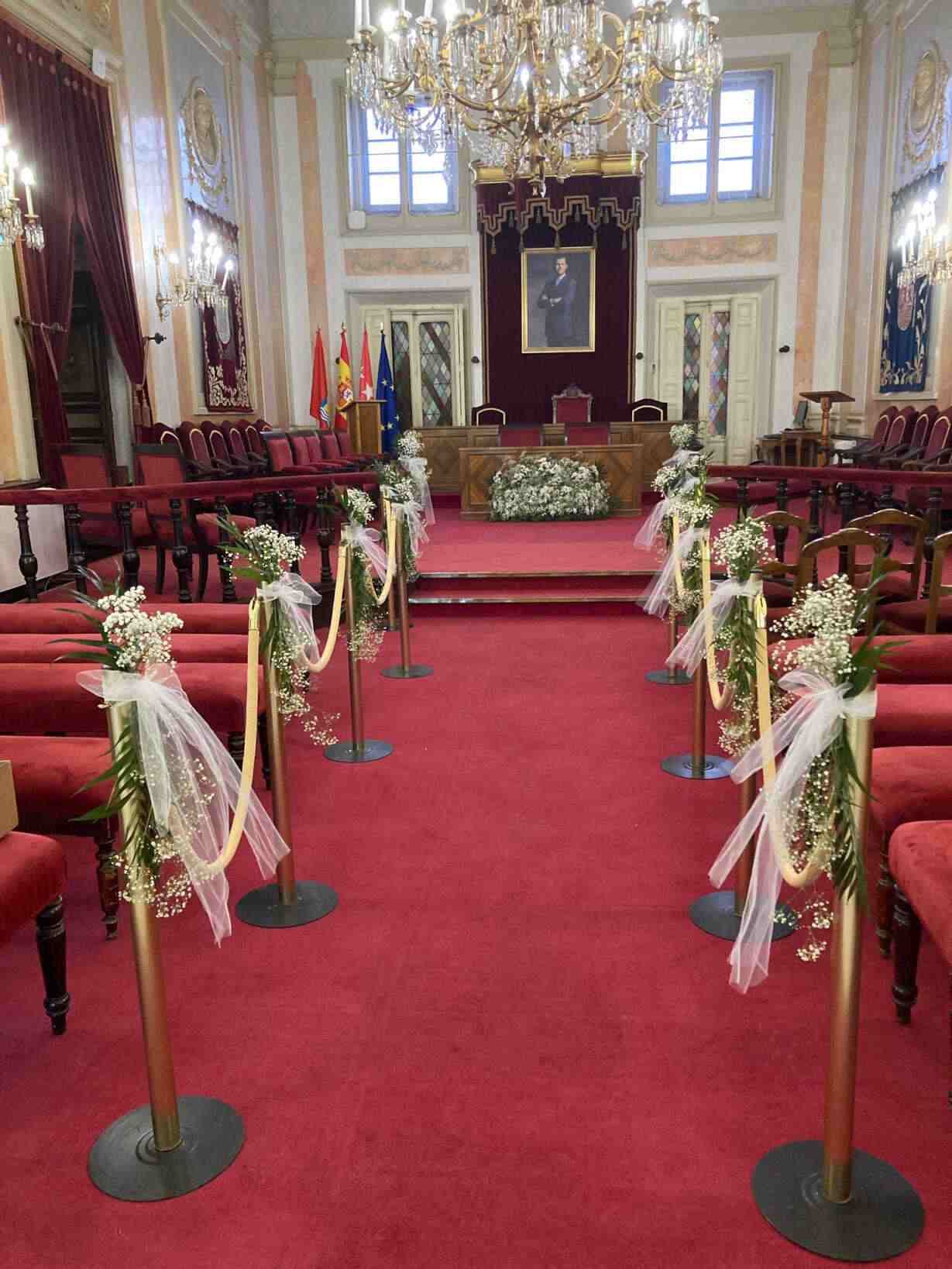 Una fila de sillas rojas en una habitación con flores.