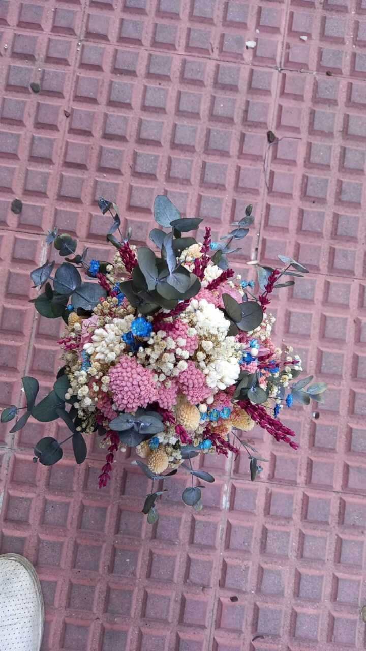 Un ramo de flores está sobre un suelo de baldosas.