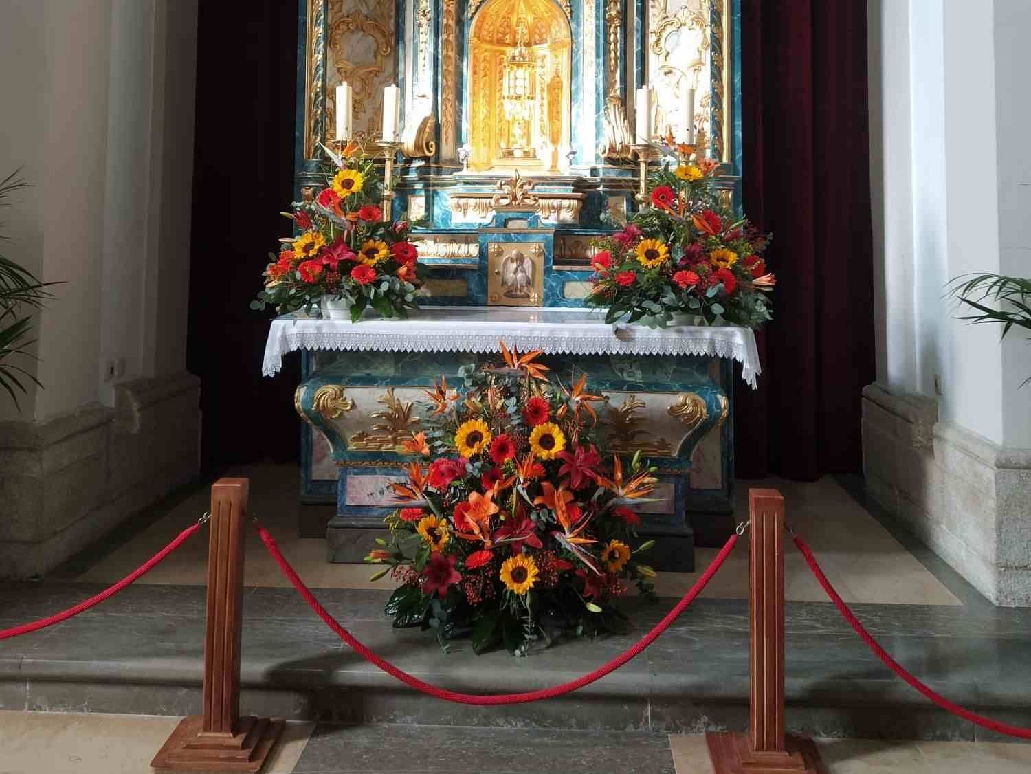 Un altar en una iglesia decorado con flores y velas.