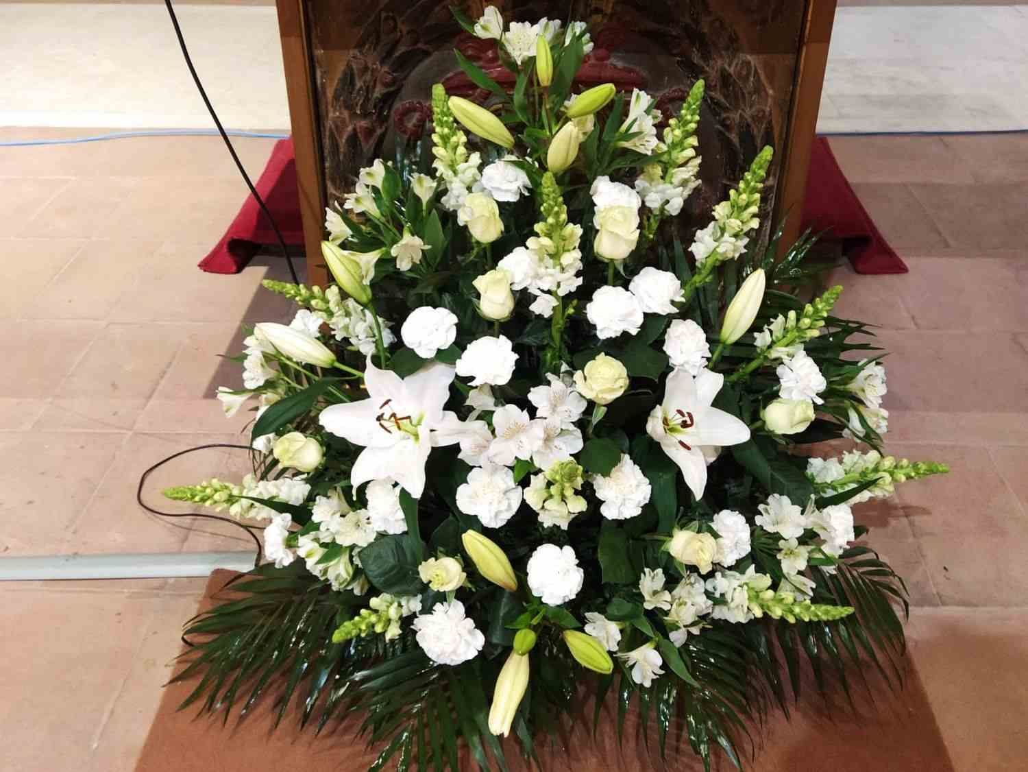 Un gran ramo de flores blancas reposa sobre una mesa.