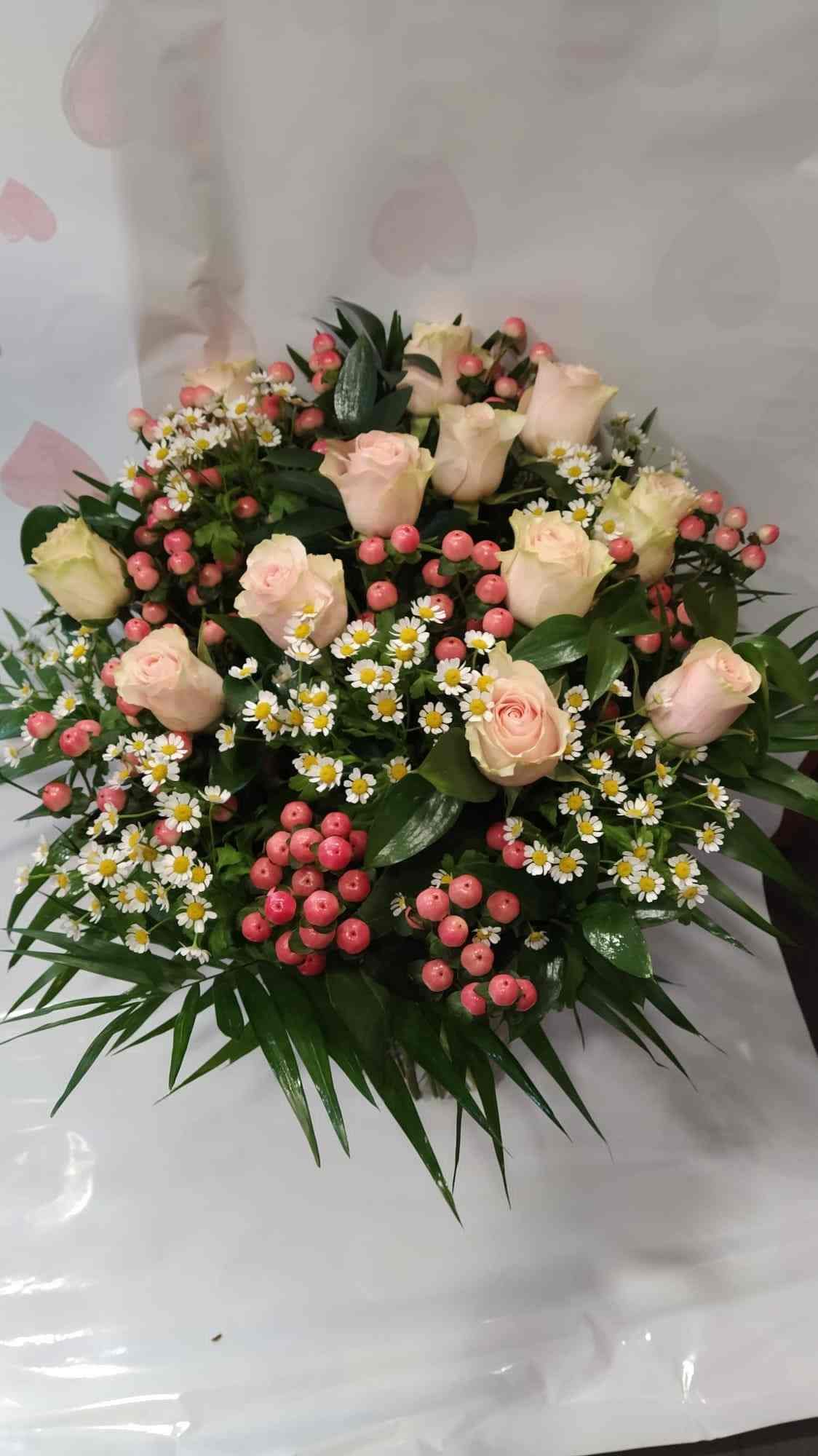 Un ramo de flores rosas y blancas está sobre una mesa.