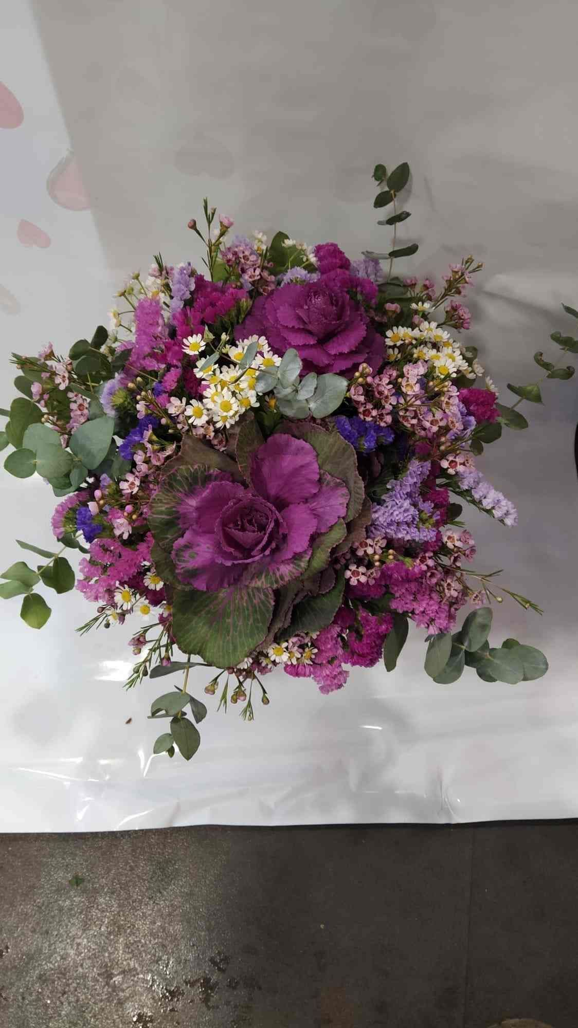 Un ramo de flores de color púrpura está sobre una mesa.