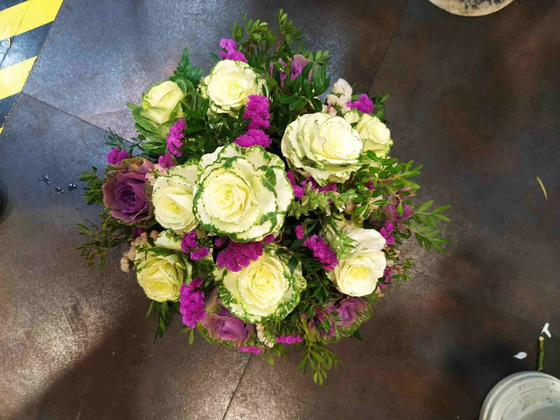 Un ramo de flores blancas y moradas sobre una mesa.