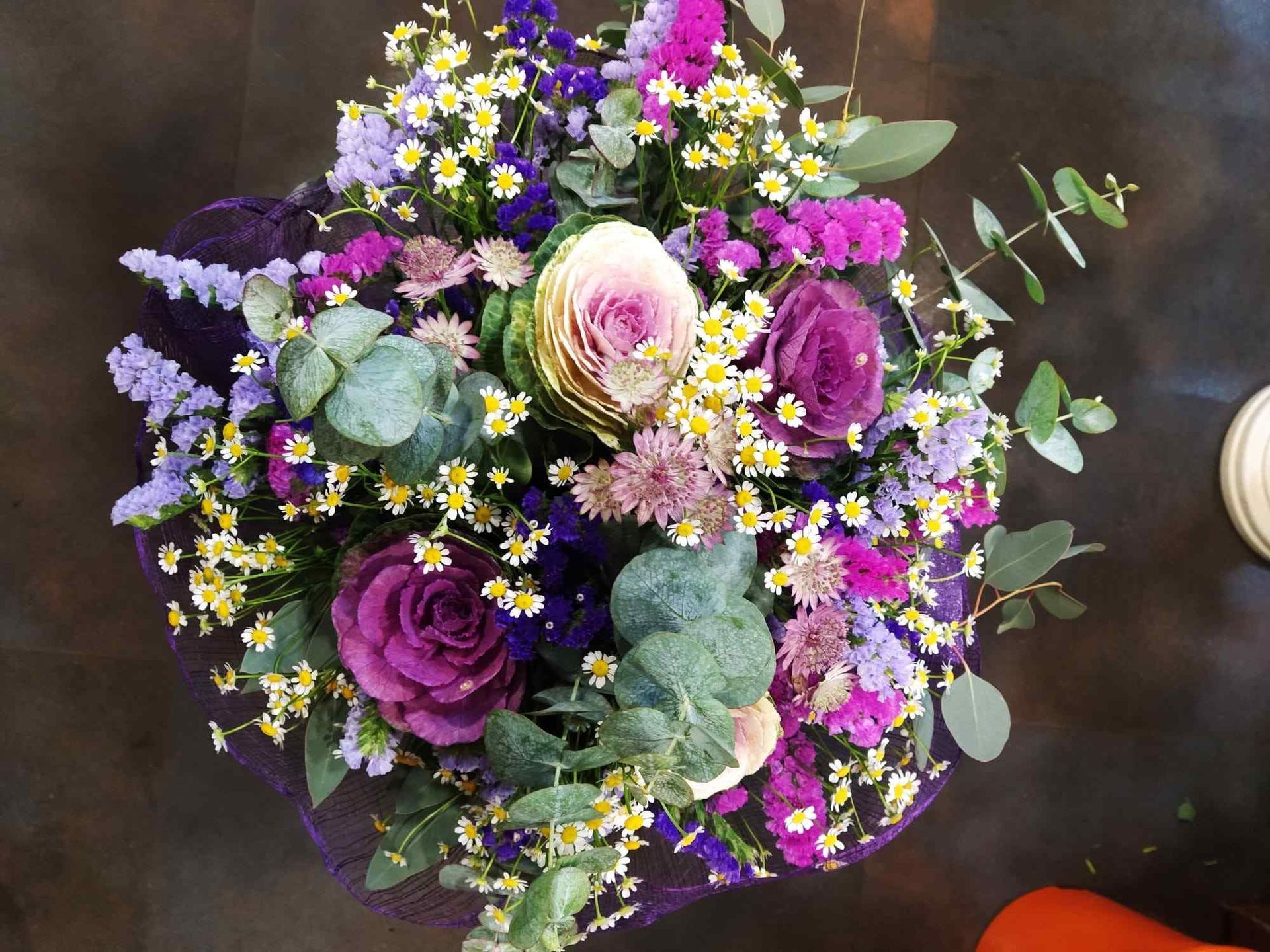 Un ramo de flores moradas y amarillas sobre una mesa.