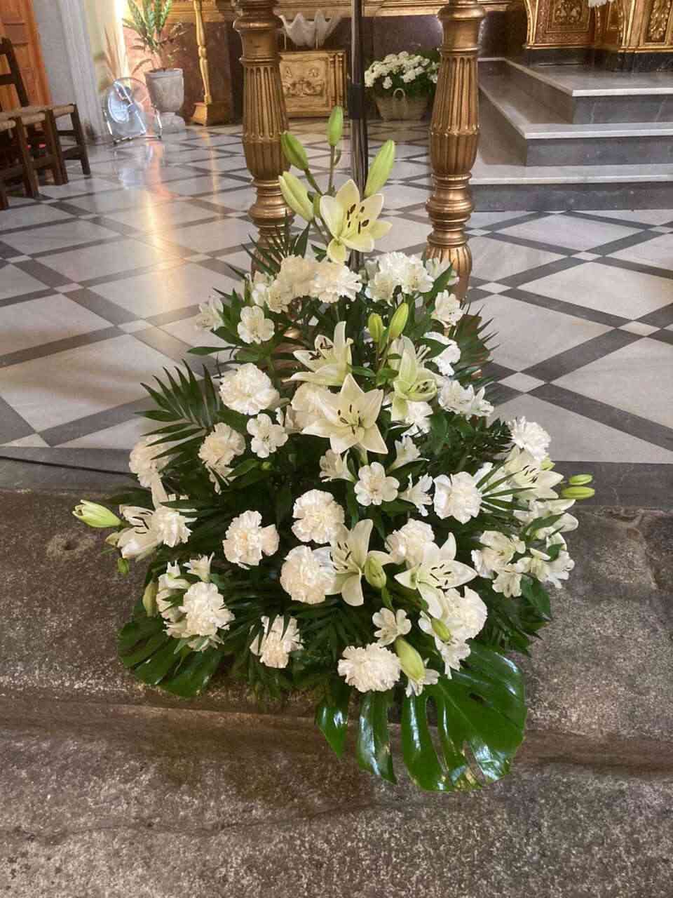 Un ramo de flores blancas está sentado en los escalones de una iglesia.