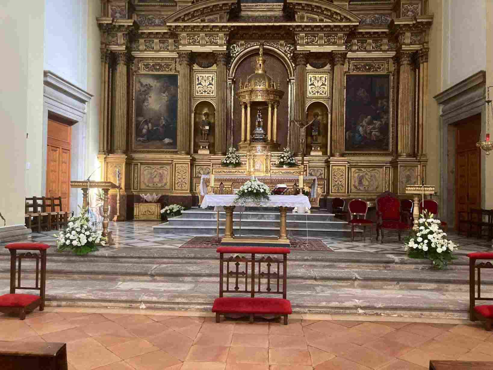 El interior de una iglesia con un altar y flores en él.