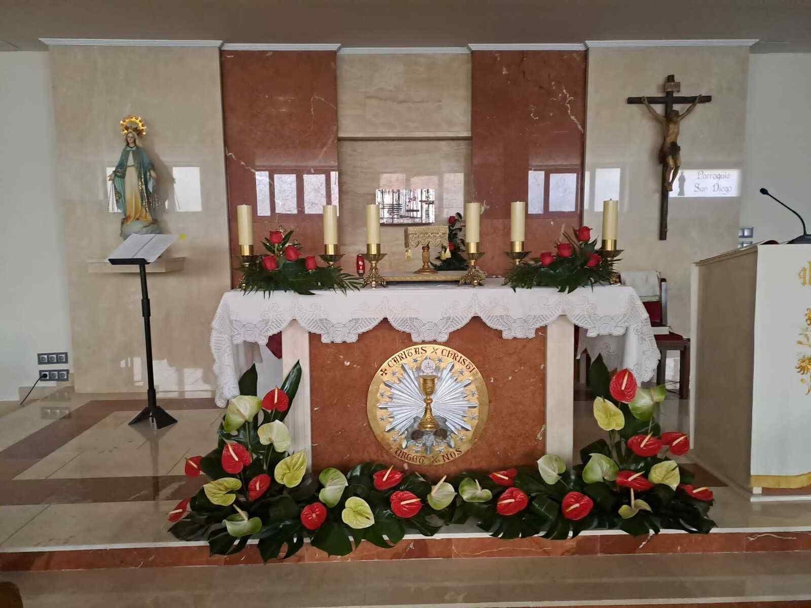 Un altar en una iglesia con flores y velas.