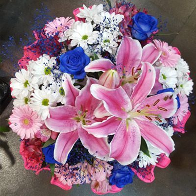 Un ramo de flores rosas y blancas con rosas azules.