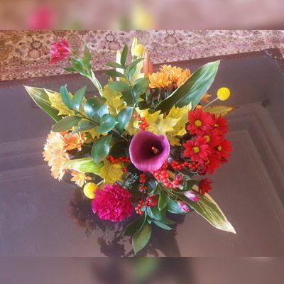 Un ramo de flores está sobre una mesa de cristal.