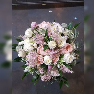 Un ramo de flores rosas y blancas con hojas verdes.