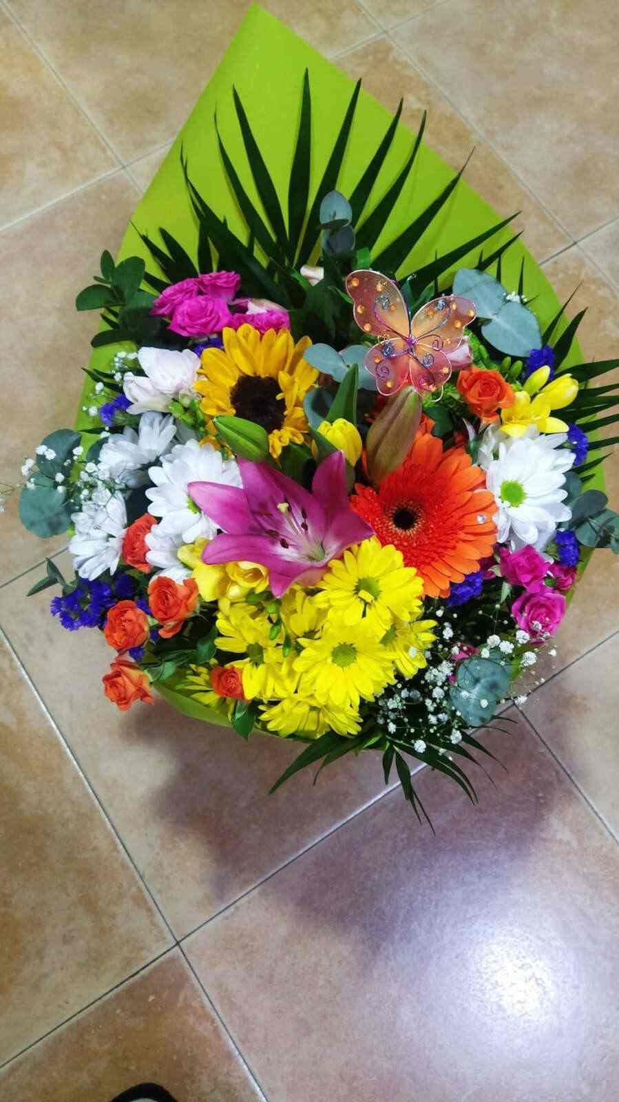 Un ramo de flores de colores está sobre un suelo de baldosas.