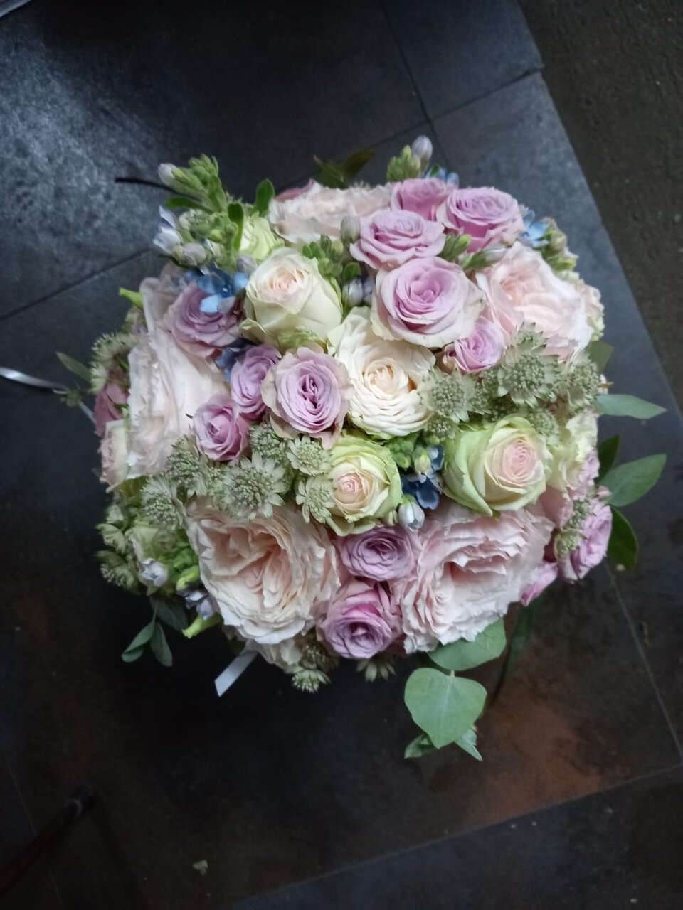 Un ramo de rosas rosadas y blancas está sobre una mesa.