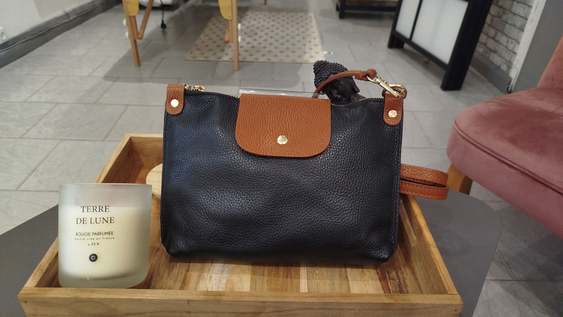 Sac et bougie sur un plateau dans un salon.