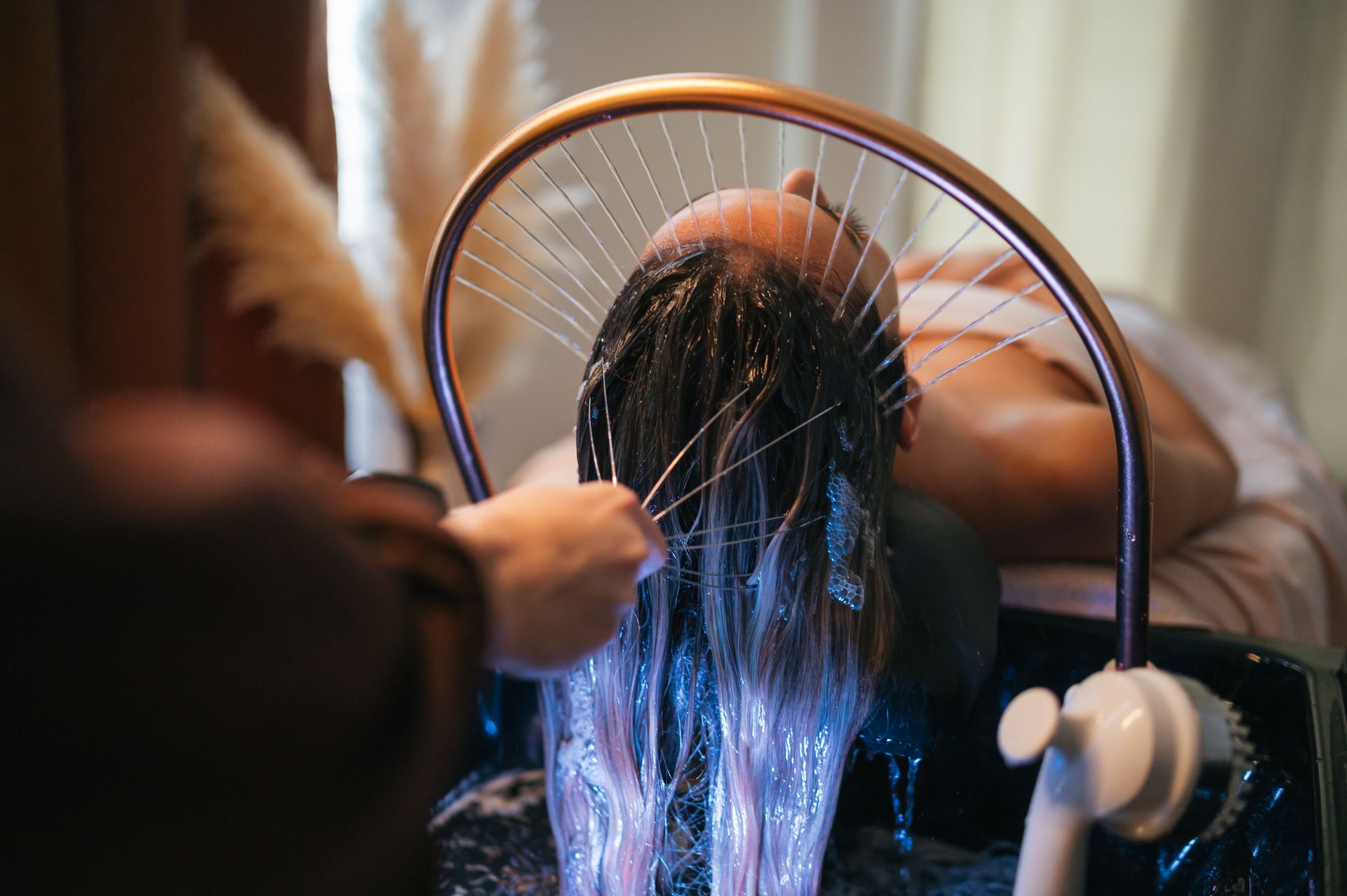 Des cheveux rincés, tandis que l’eau jaillit d’une douchette incurvée.