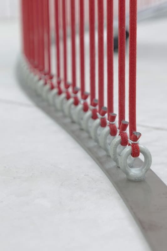 Una fila de postes rojos con anillos unidos a ellos.