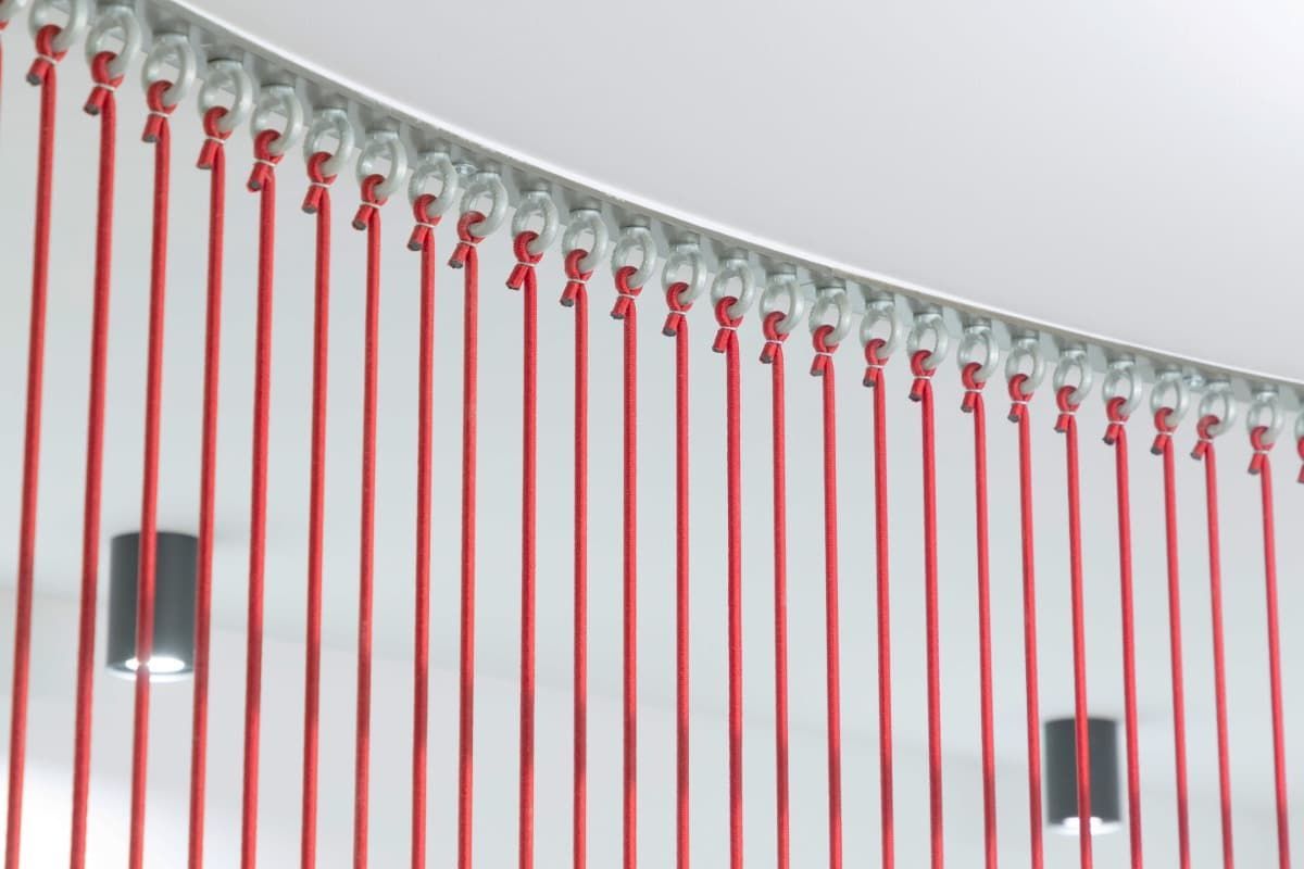 Una fila de palos rojos cuelgan del techo.