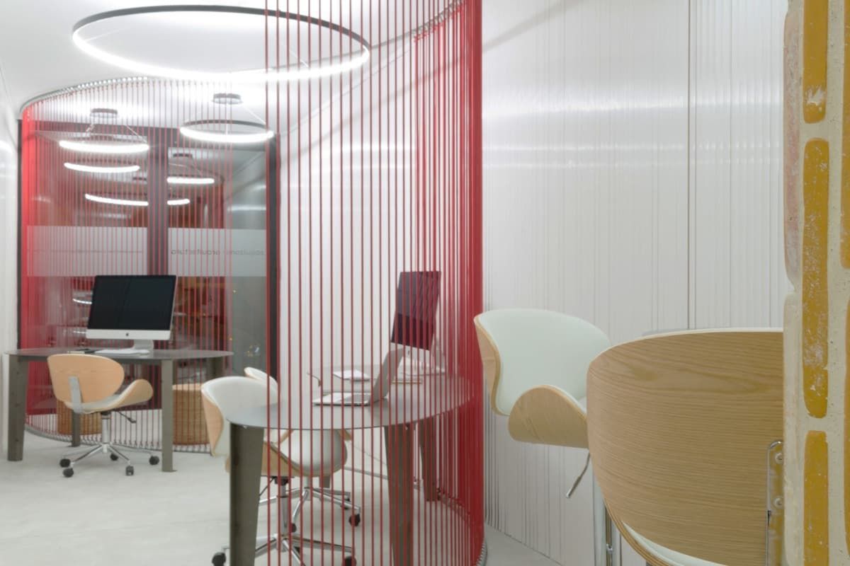 Una habitación con una computadora en un escritorio y sillas.