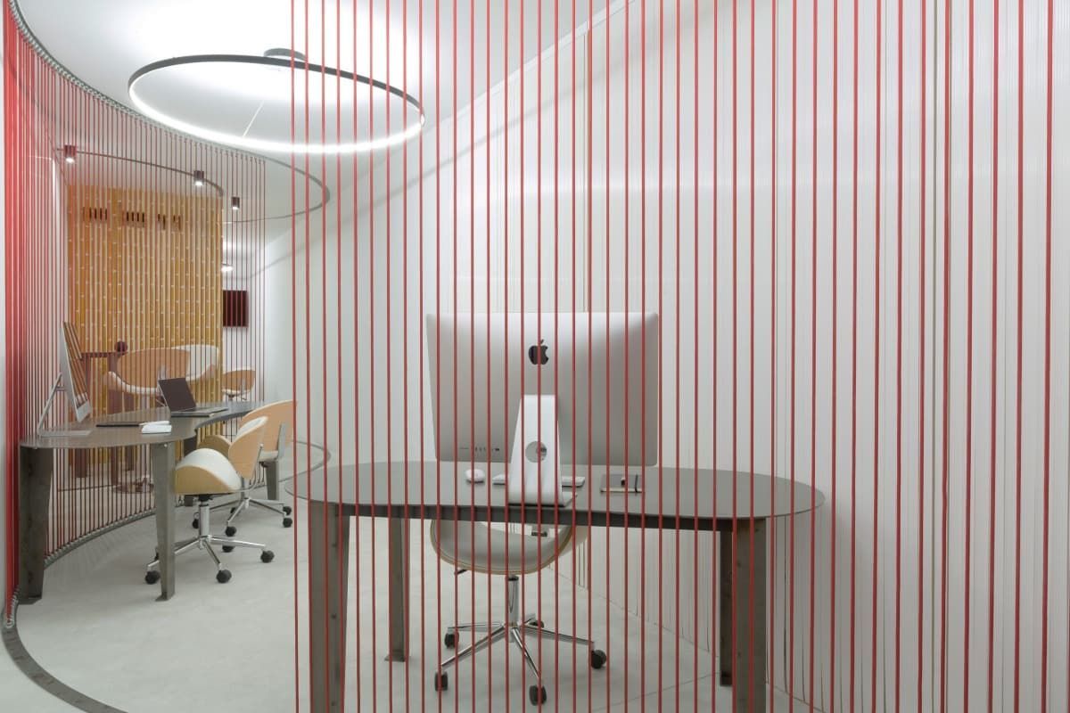 Un escritorio con una computadora encima en una habitación con una pared rayada.