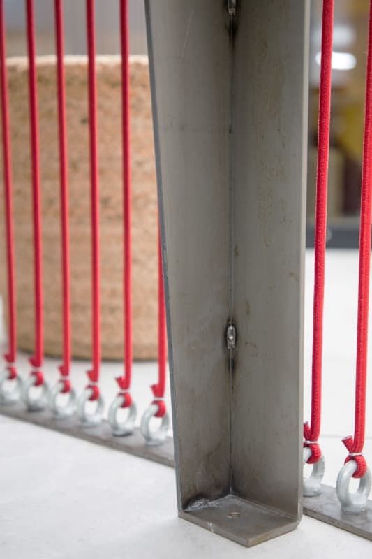 Un primer plano de una barandilla de metal con cables rojos colgando de ella.