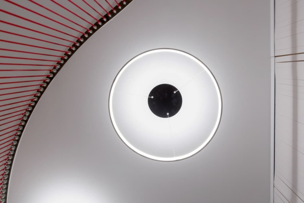 Un círculo blanco con un centro negro cuelga del techo.
