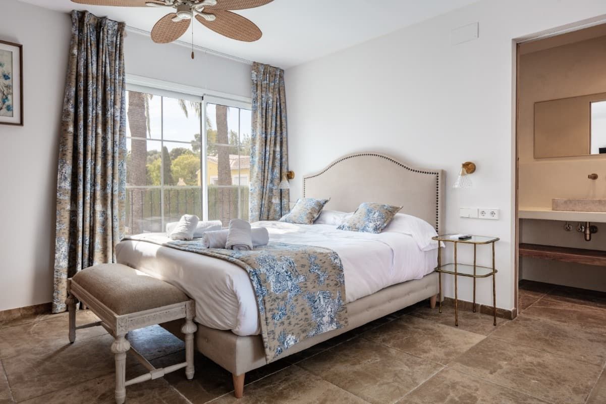 Un dormitorio con una cama grande y un ventilador de techo.