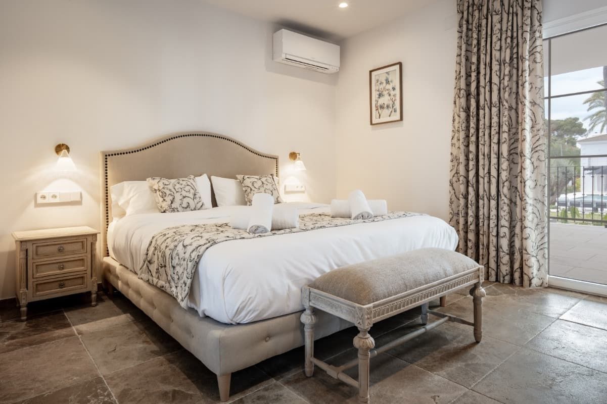 Un dormitorio con una cama king size y un banco.