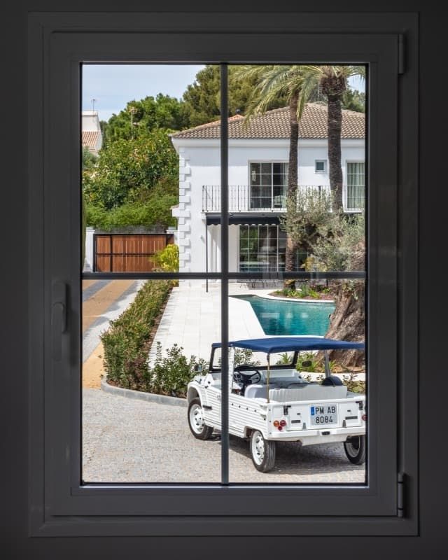 Un coche blanco está aparcado delante de una casa.