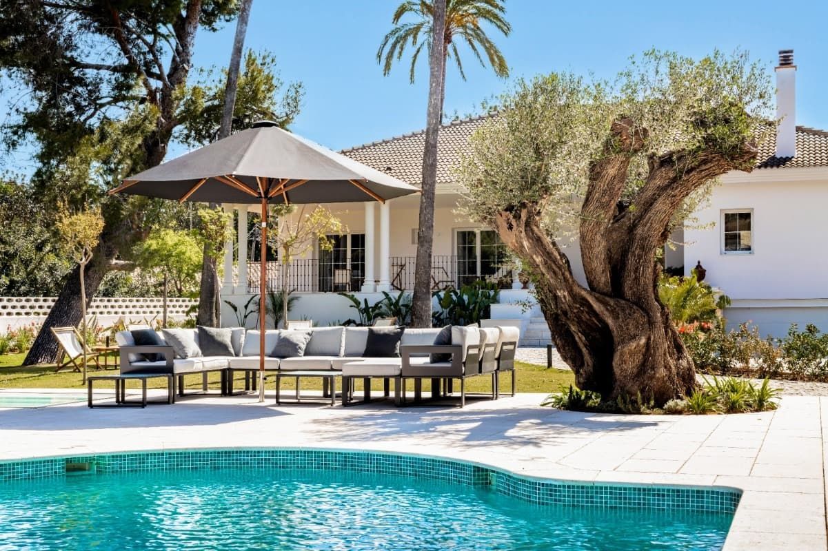 Una casa grande con piscina delante de ella.